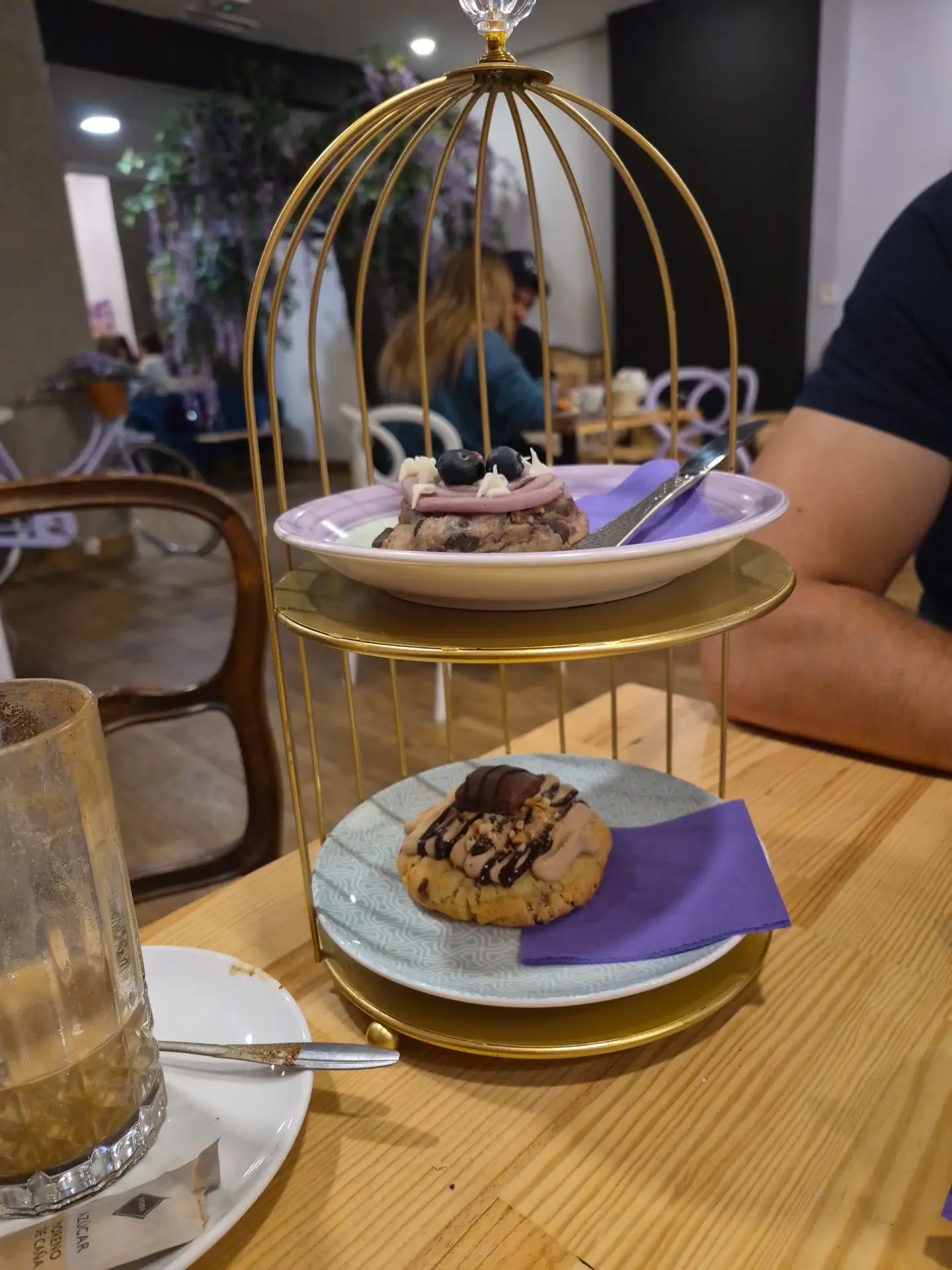 Dulces de Lyere en su jaula dorada, con la glicinia al fondo